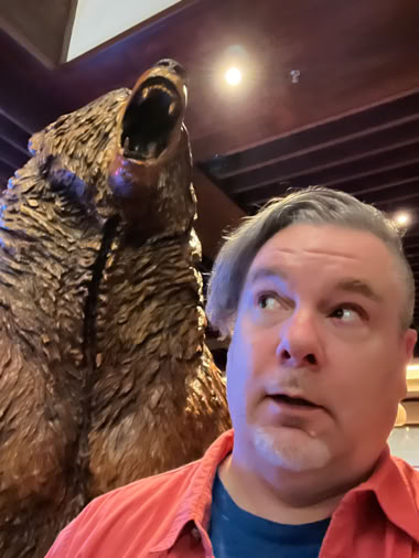 Photo of Walden looking over his shoulder at a bear sculpture